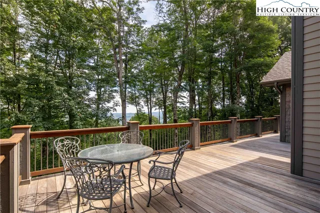a balcony with wooden floor table and chairs