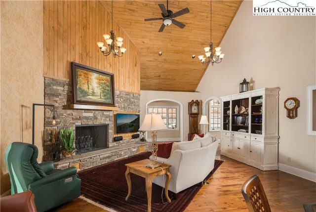 a living room with furniture a fireplace and a chandelier