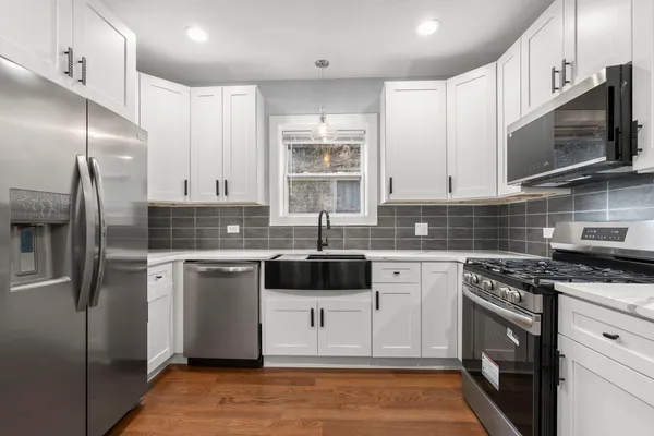 a kitchen with stainless steel appliances granite countertop a stove a sink and a microwave