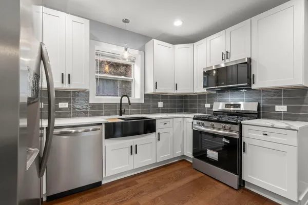a kitchen with stainless steel appliances kitchen island granite countertop a refrigerator and a stove top oven