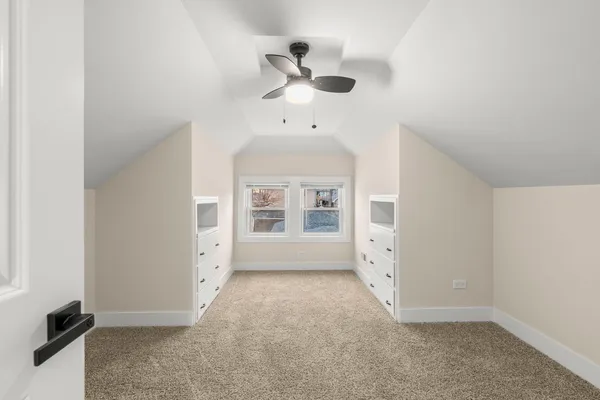 an empty room with windows and fan