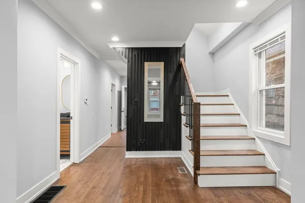 a view of a hallway with wooden floor and entryway