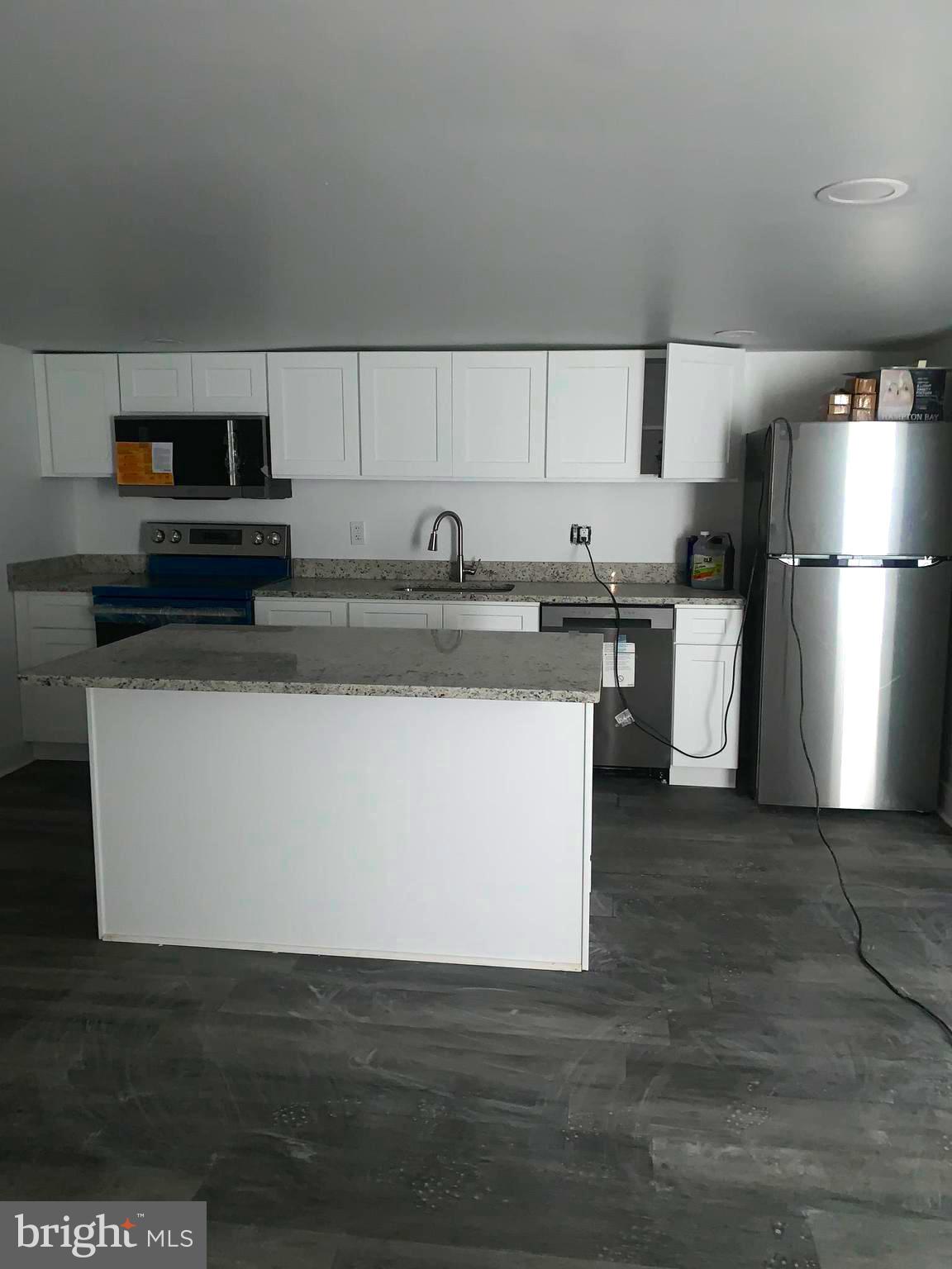 4906 Harford Road Baltimore, MD 21214 - Photo 25 of 31 a view of a kitchen with stainless steel appliances granite countertop a stove a refrigerator and a sink