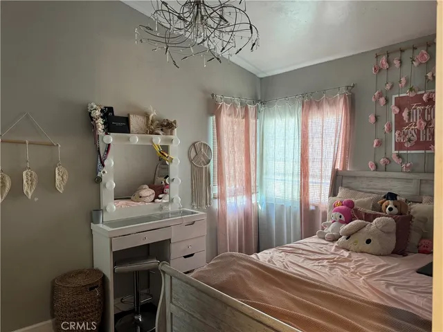 a bedroom with a bed and a chandelier