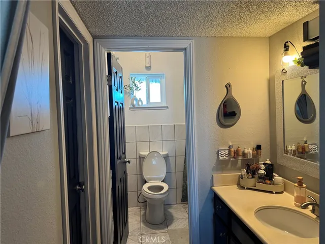 a bathroom with a toilet a sink and mirror