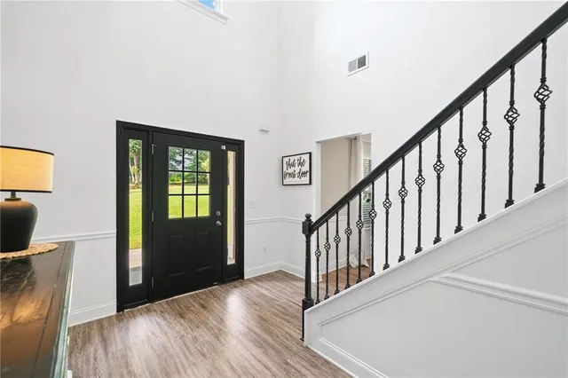 a view of a hallway with wooden floor and stairs