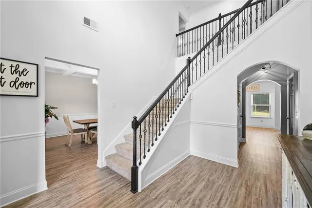 a view of staircase and kitchen with wooden floor