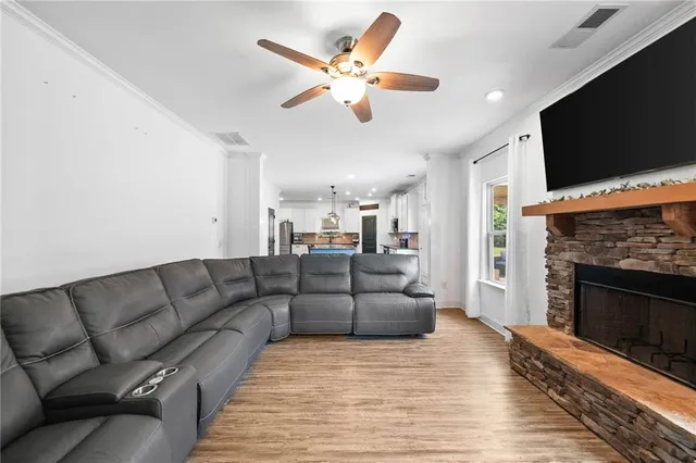 a kitchen with stainless steel appliances granite countertop a refrigerator a stove top oven and a wooden floors