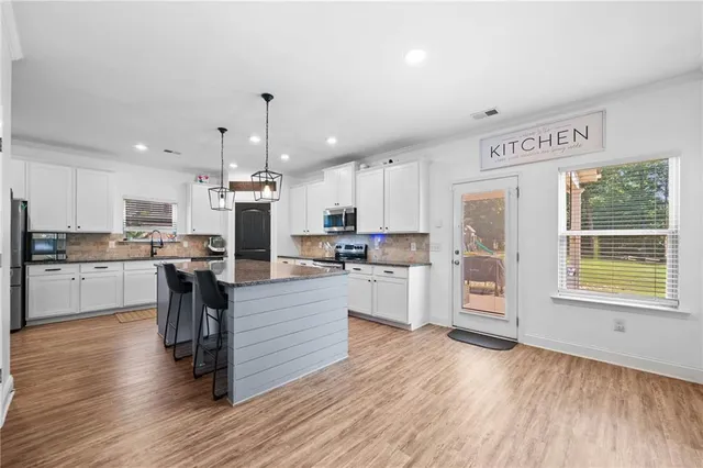 a large kitchen with stainless steel appliances granite countertop a stove and refrigerator
