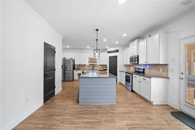 a large kitchen with stainless steel appliances granite countertop a stove a sink and a granite counter tops