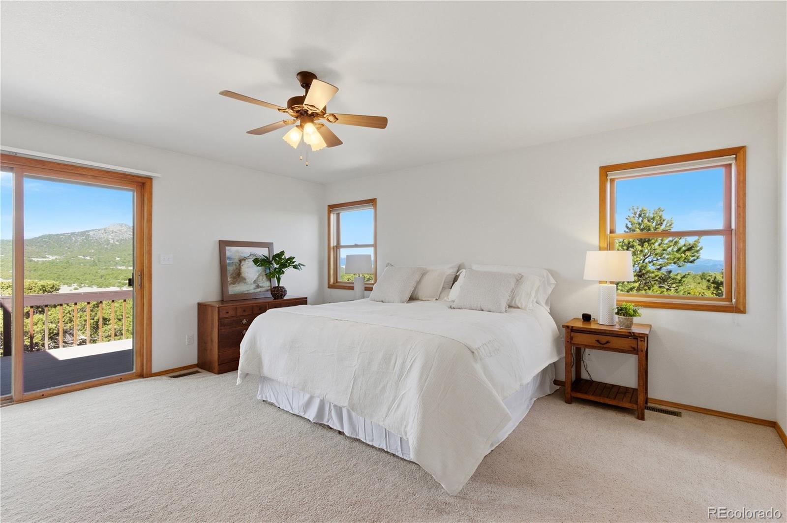 90 Riggs Road Westcliffe, CO 81252 - Photo 12 of 35 a spacious bedroom with a bed and a chandelier