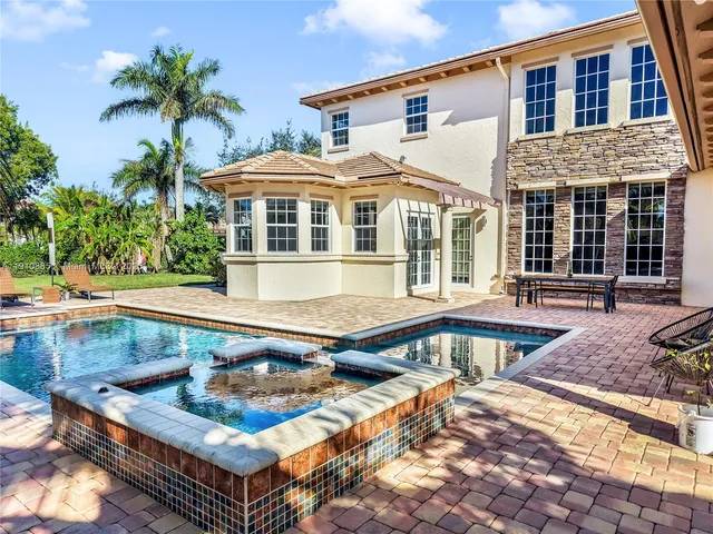a front view of a house with swimming pool and sitting area