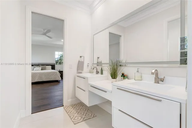 a spacious bedroom with a bed a dresser and wooden floor