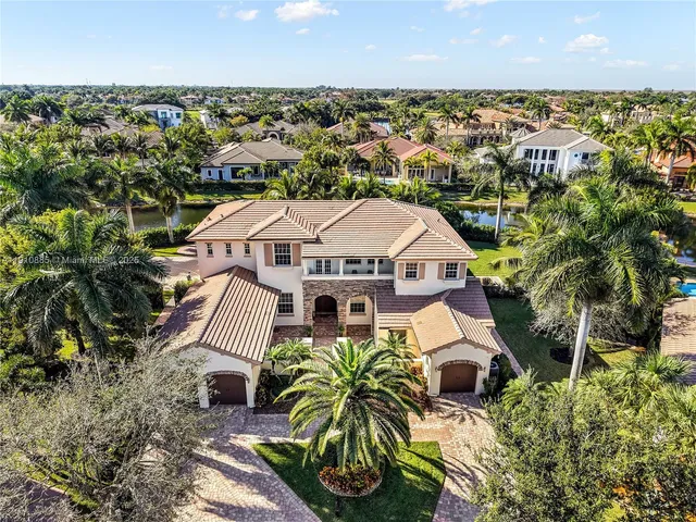 an aerial view of a house with a yard lake and outdoor seating