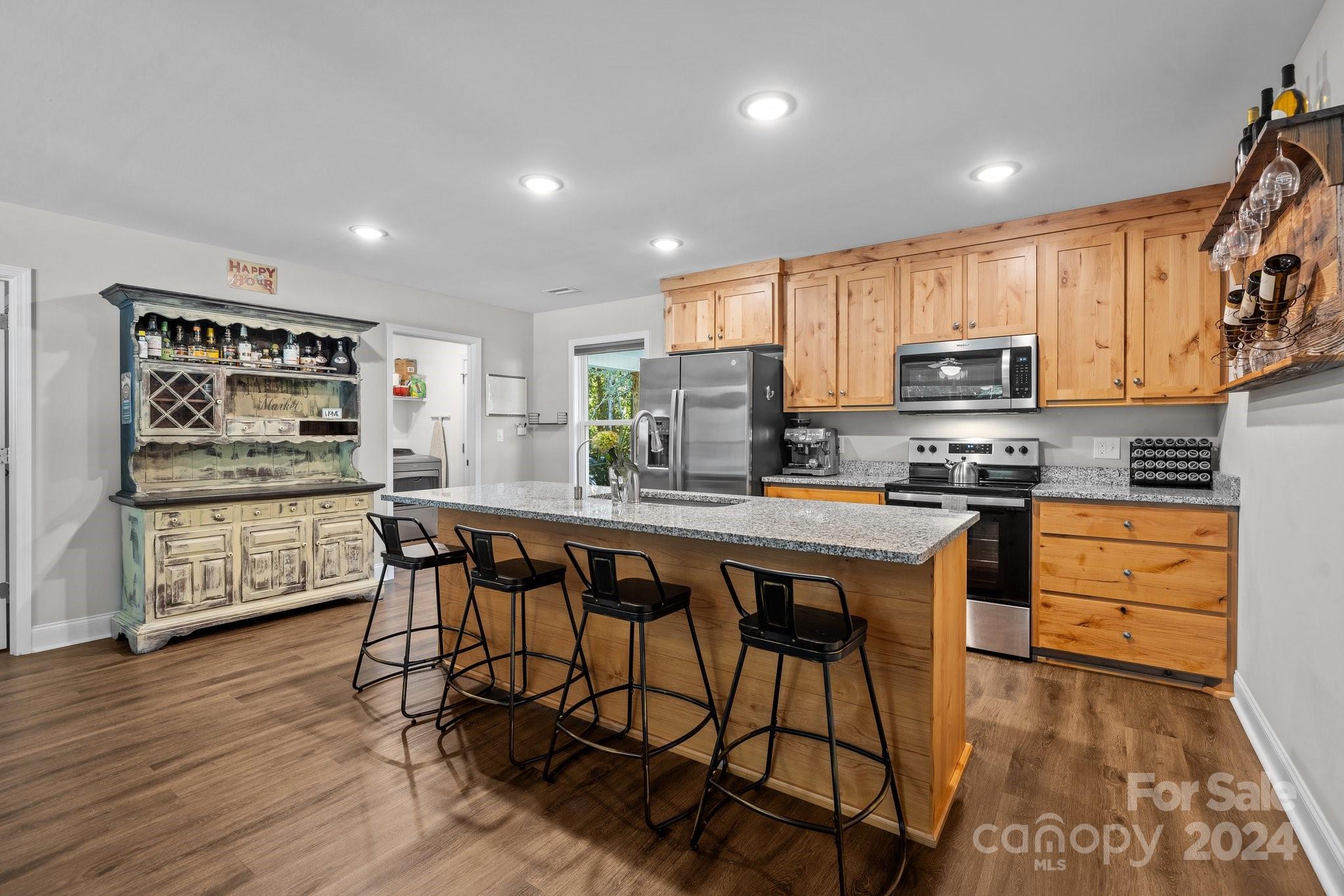 1455 Lawrence Road Clover, SC 29710 - Photo 5 of 35 a kitchen with stainless steel appliances kitchen island granite countertop a refrigerator a stove a sink a dining table and chairs with wooden floor