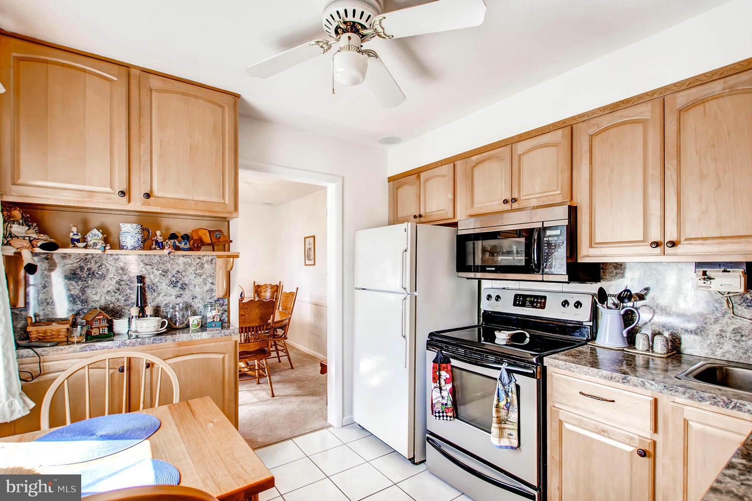 407 Homewood Road Linthicum, MD 21090 - Photo 6 of 23 a kitchen with stainless steel appliances a stove a sink a microwave and cabinets