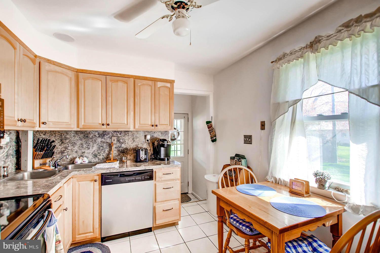 407 Homewood Road Linthicum, MD 21090 - Photo 7 of 23 a kitchen that has a table chairs and a refrigerator