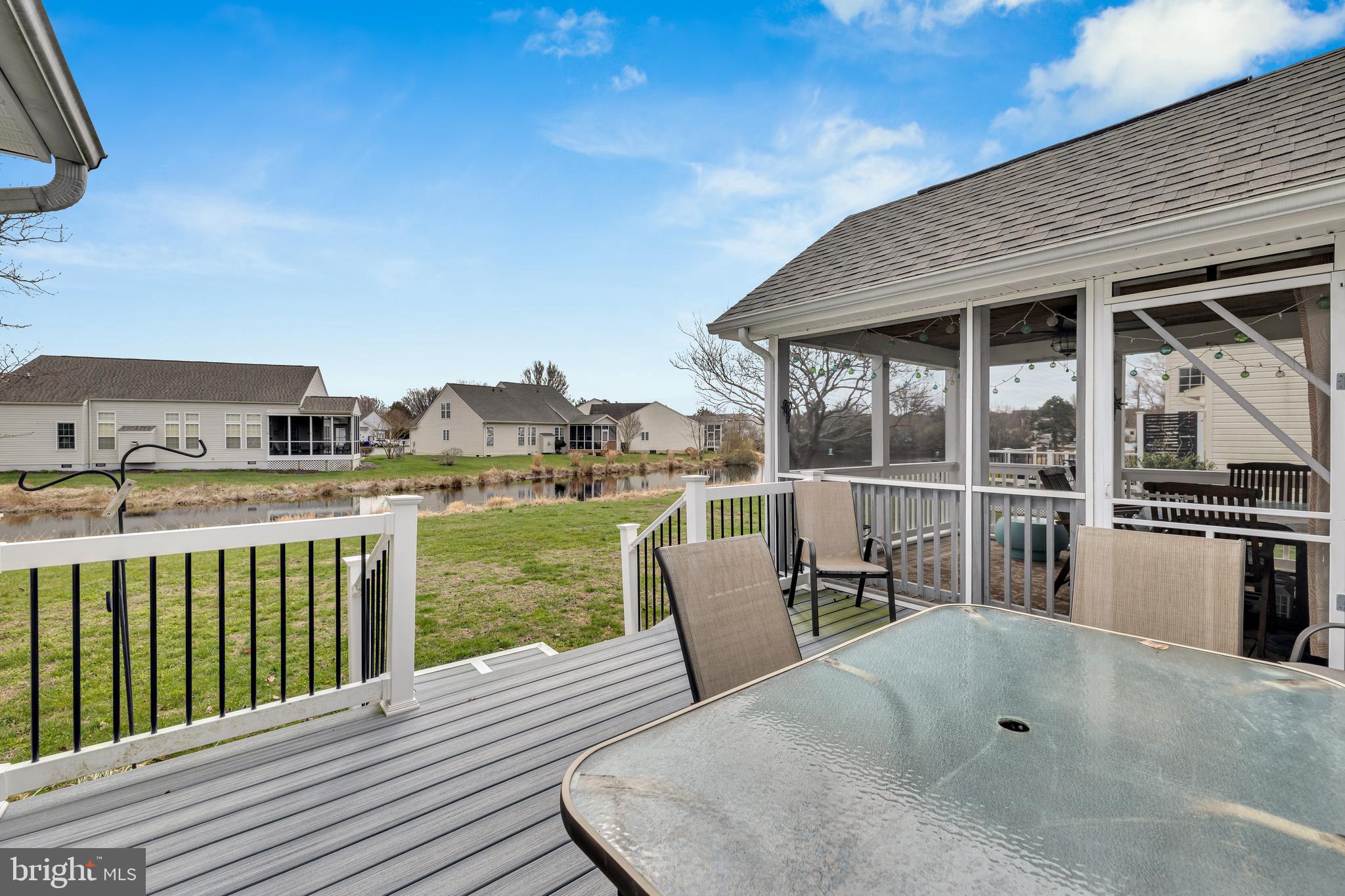 33525 Westhampton Lane Ocean View, DE 19970 - Photo 27 of 49 a roof deck with a table and chairs next to a yard
