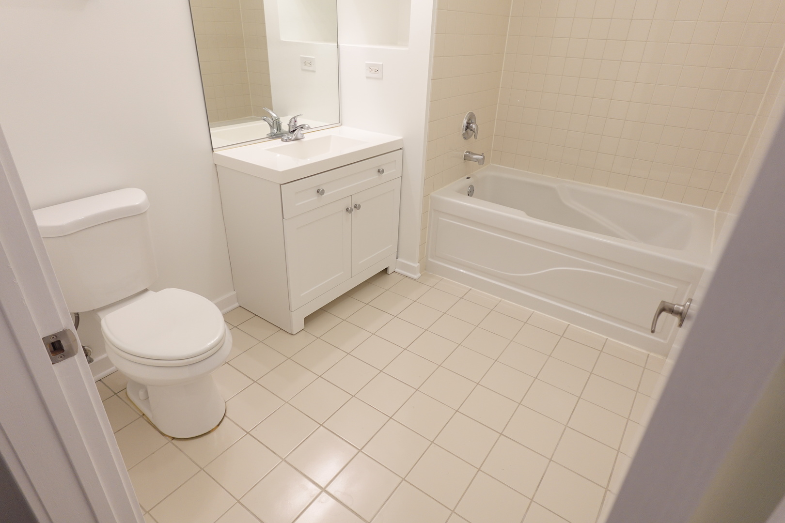 3963 West Belmont Avenue, Unit 219 Chicago, IL 60618 - Photo 21 of 28 a bathroom with a white bath tub a toilet and a sink