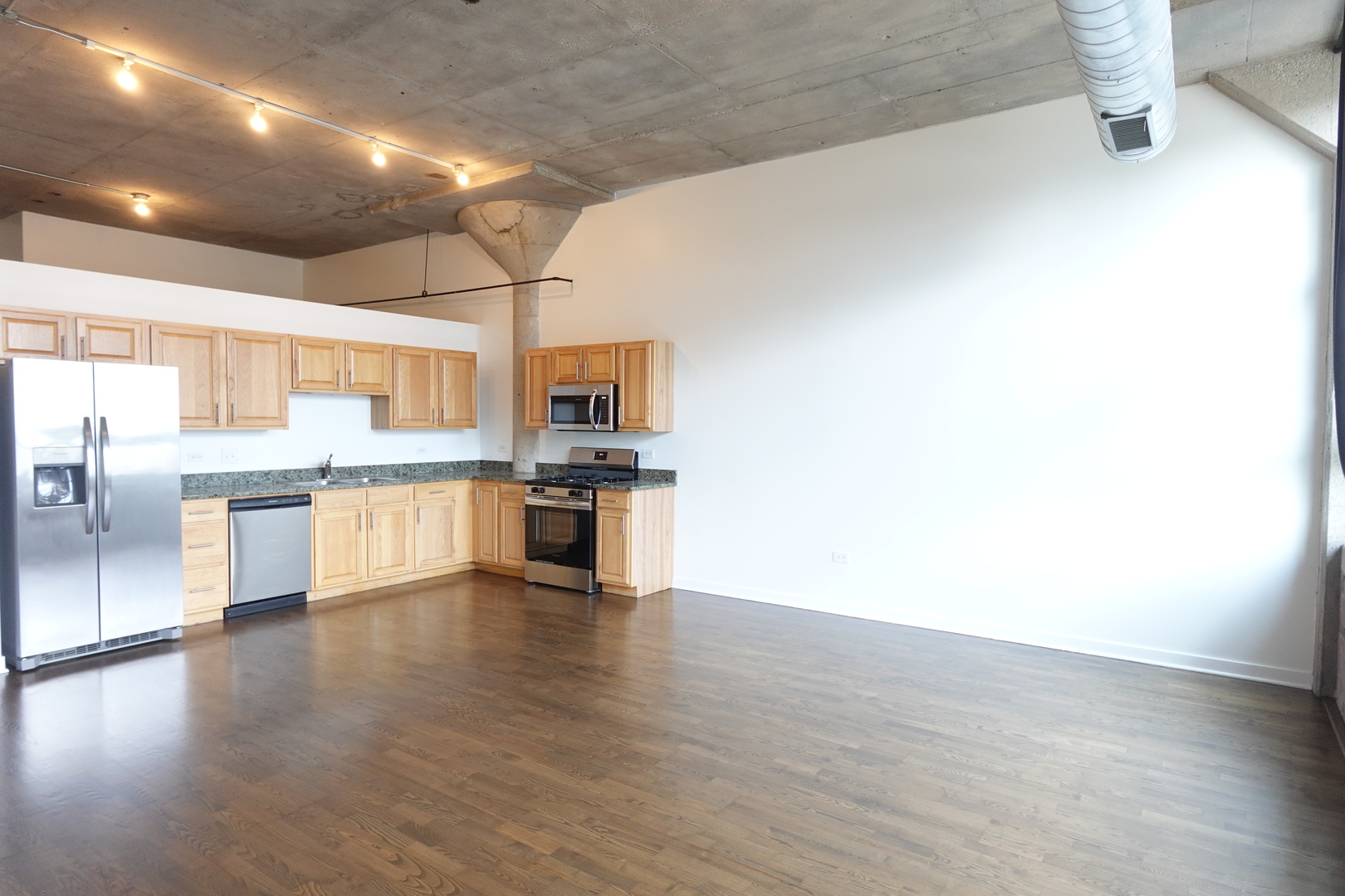 3963 West Belmont Avenue, Unit 219 Chicago, IL 60618 - Photo 7 of 28 a large kitchen with white cabinets and stainless steel appliances