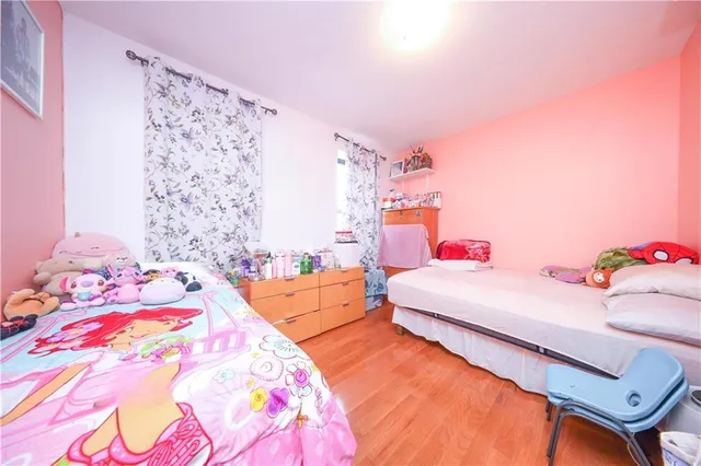 a bedroom with a bed and a lamp on the dresser