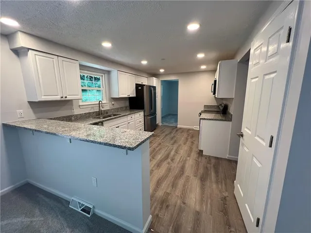 a view of kitchen with sink refrigerator and microwave