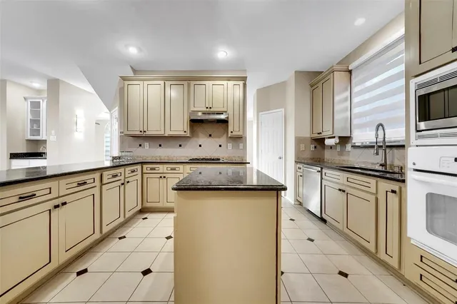 a kitchen with stainless steel appliances granite countertop a sink stove and cabinets