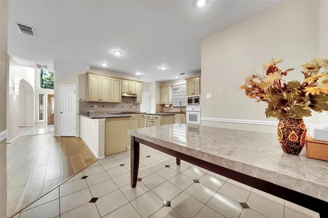 a kitchen with stainless steel appliances kitchen island granite countertop a sink a counter space and cabinets