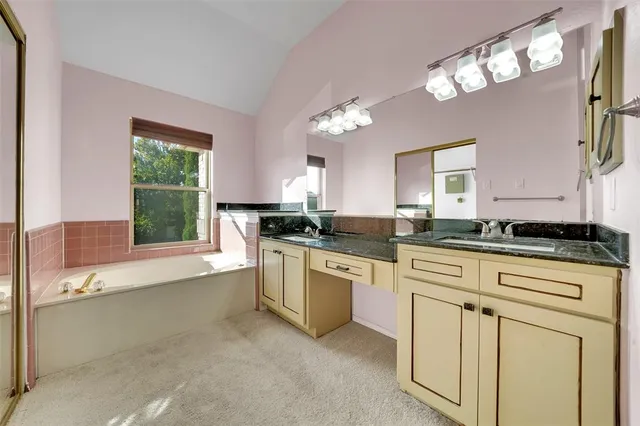 a kitchen with white cabinets and window