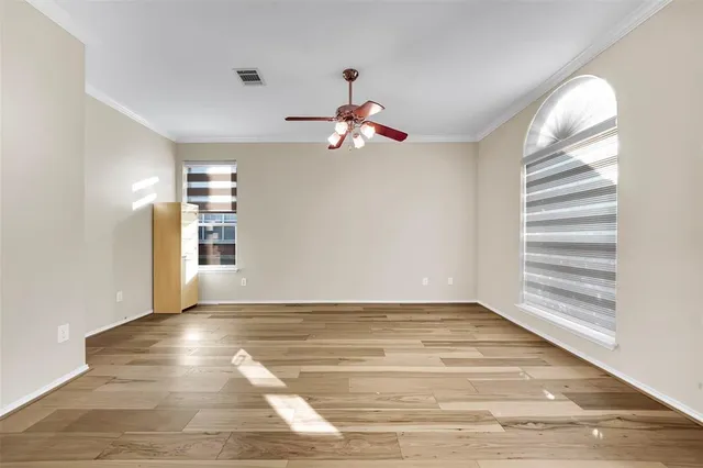 a view of a room with wooden floor and a ceiling fan