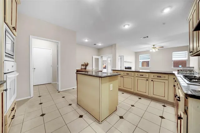 a kitchen with stainless steel appliances granite countertop a refrigerator and a stove top oven