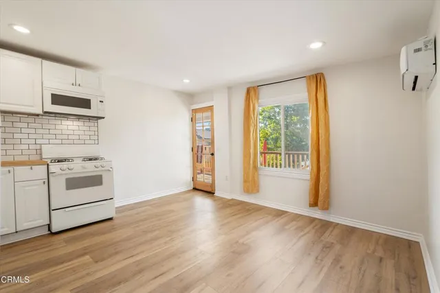 a view of a kitchen with wooden floor and electronic appliances