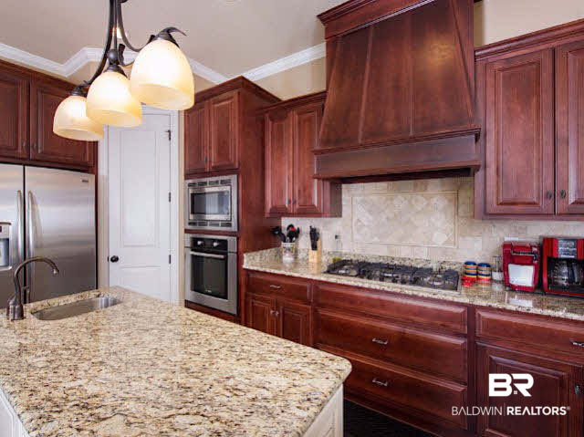 7814 Balin Drive Daphne, AL 36527 - Photo 7 of 26 Custom Kitchen with plenty of lighting and storage space, breakfast nook, breakfast bar, granite counter tops, multiple sinks, and stainless appliances for all your chef dreams!