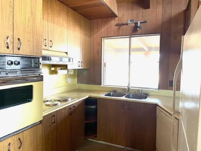 a kitchen with a sink a counter top space cabinets and a large window