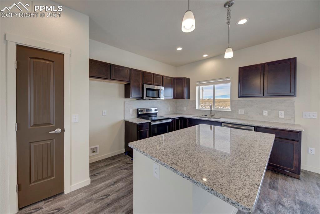 1075 Yoder Road Yoder, CO 80864 - Photo 4 of 14 a kitchen with stainless steel appliances granite countertop a sink refrigerator and microwave