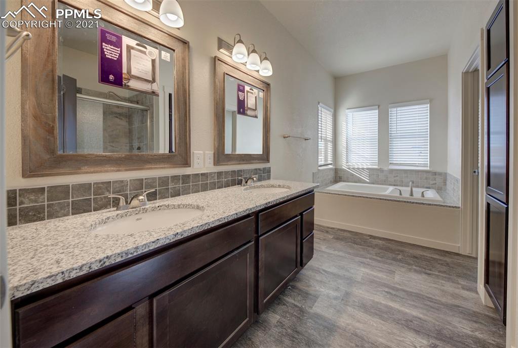 1075 Yoder Road Yoder, CO 80864 - Photo 6 of 14 a bathroom with double vanity sinks a large mirror and a bathtub