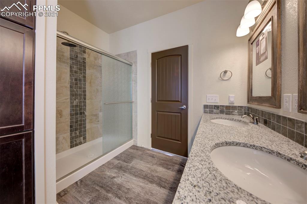 1075 Yoder Road Yoder, CO 80864 - Photo 9 of 14 a bathroom with a granite countertop sink a mirror and shower