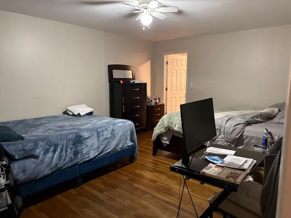 a bedroom with a bed and a computer on a desk