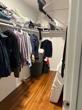 a view of walk in closet with clothes and shoes