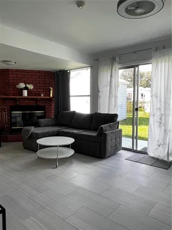 a living room with furniture and a floor to ceiling window