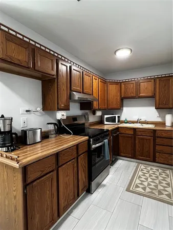 a kitchen with stainless steel appliances granite countertop a stove sink microwave and cabinets
