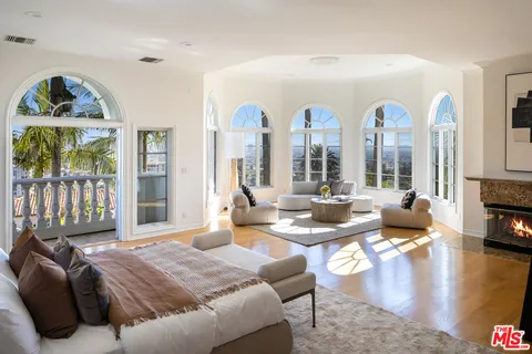 a living room with furniture fireplace and a large window