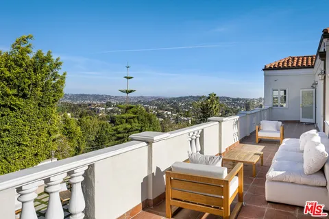 an aerial view of a house with a swimming pool and outdoor seating