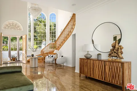 a workspace with furniture bookshelf and a large window