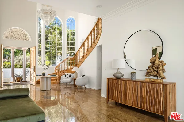 a workspace with furniture bookshelf and a large window