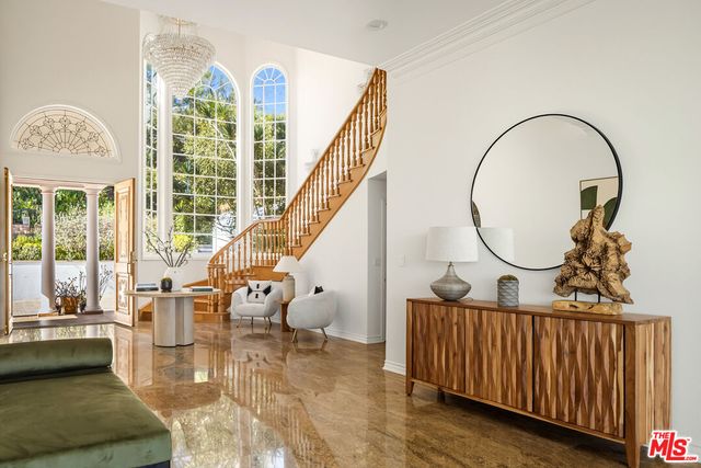 a workspace with furniture bookshelf and a large window