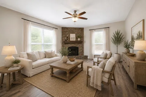 a living room with furniture a fireplace and a large window