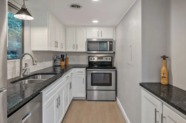 a kitchen with a refrigerator a sink and cabinets