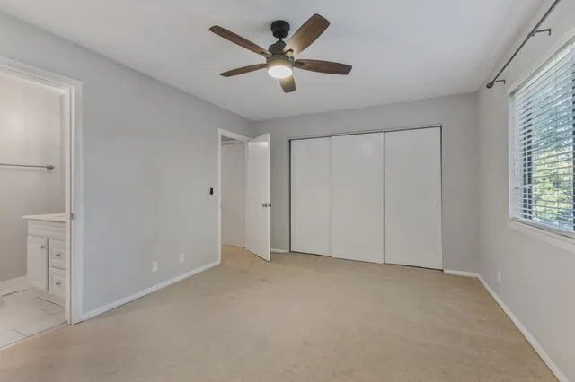 a view of an empty room and a ceiling fan