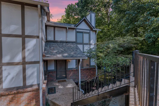 a view of a house with a small yard and wooden floor and fence